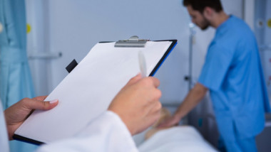 Un medic se uita pe fisa unui pcient
