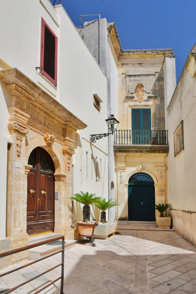 A narrow street between the old houses of Presicce, a picturesque village in the province of Lecce in Italy.