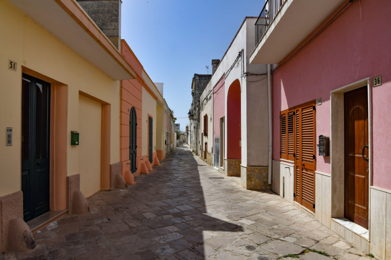 A narrow street between the old houses of Presicce, a picturesque village in the province of Lecce in Italy.