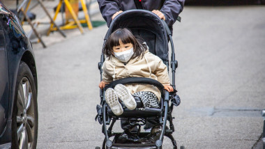 copil sud-coreean în cărucior, pe stradă