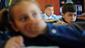 elevi într-o sală de clasă din România, o fetiță pune mâna la gură