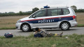 A police van passes by a young migrant resting on his way to the train station in Nickelsdorf, Austria