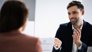 Un bărbat gesticulează în timpul unui interviu de angajare