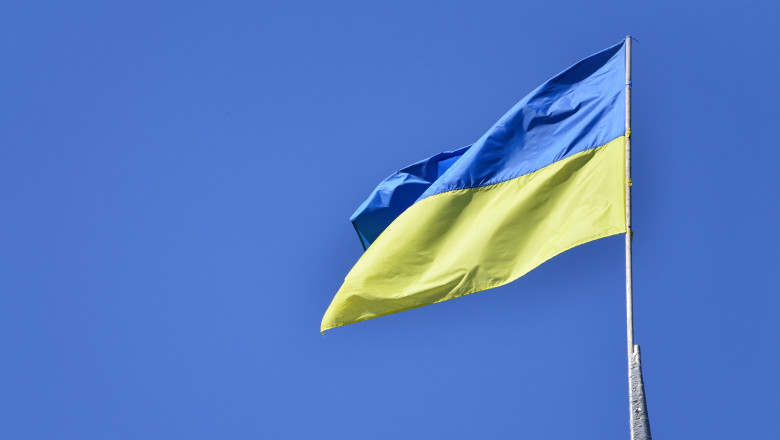 Ukrainian flag against the blue cloudless sky. The official flag of the Ukrainian state includes yellow and blue colors