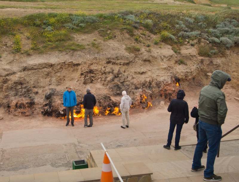 Yanar Dag, the burning mountain, in Baku Azerbaijan, a continuing natural gas fire showing the deposits below ground, cold tourists getting close