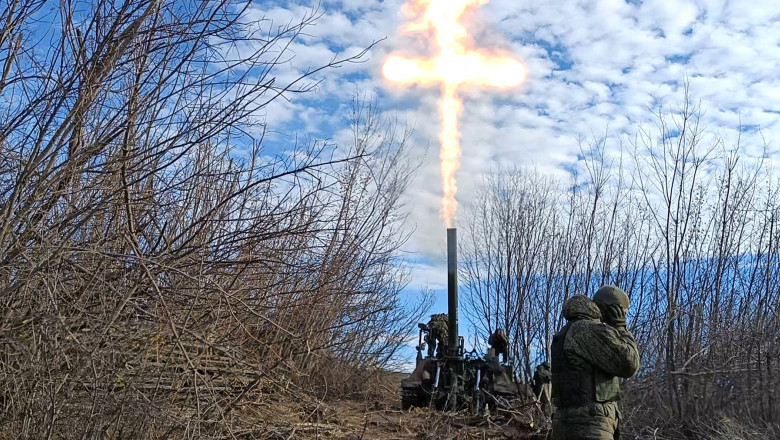 militari ruși trag cu un mortier, semnul crucii făcut de focul de la gura țevii