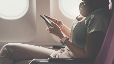 pasageră în avion vorbește la telefon, folosește telefonul în timpul zborului