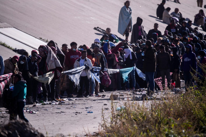 TX: Migrants wait on North embankment of the Rio Grande