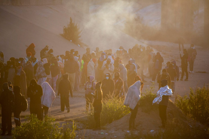 TX: Migrants wait on North embankment of the Rio Grande