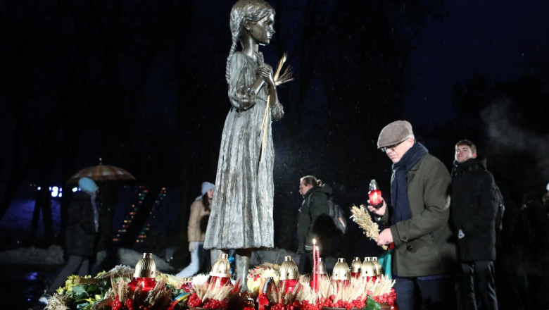 Ucrainenii depun spice de grâu la statuia denumită "Amintirea unei copilării amare" ridicată în faţa Muzeului Genocidului Holodomor din Kiev.