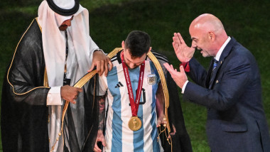 Lionel Messi îmbrăcat într-o mantie neagră de emir în timp ce Gianni Infantino privește