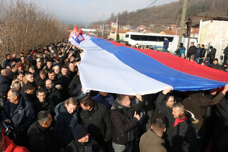 Sârbi kosovari care țin pe mâini un steag al Serbiei