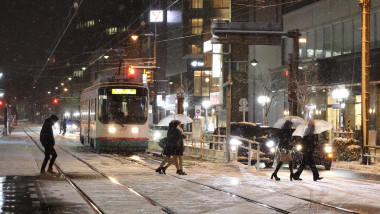 oameni pe o stradă din Toyama, Japonia, în timpul unei ninsori