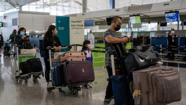 oameni cu măști și bagaje într-un aeroport