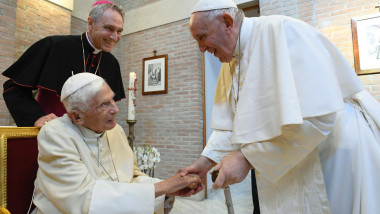 Papa Francisc îi ține mâna predecesorului său, Benedict