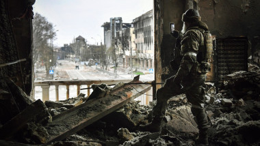 Un soldat rus filmează cu telefonul mobil ruinele teatrului din Mariupol bombardat pe 12 aprilie 2022