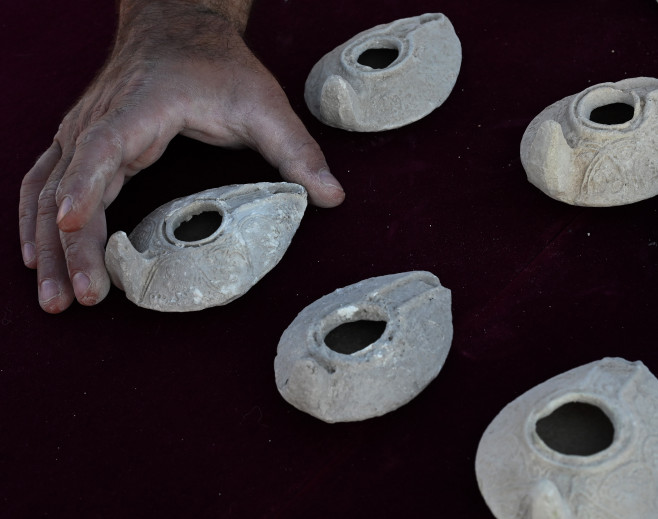 An Archeologist For The Israel Antiquities Authority Holds A Clay Lamp Found Outside The Salome Cave In The Lachish Forest