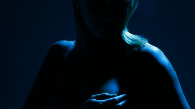 femeie cu mana pe san, imagine in umbra albastra