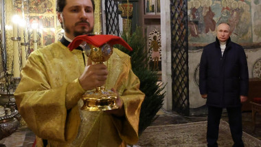 Vladimir Putin se uită la un preot ortodox rus în timpul slujbei de Crăciun pe rit vechi la Kremlin