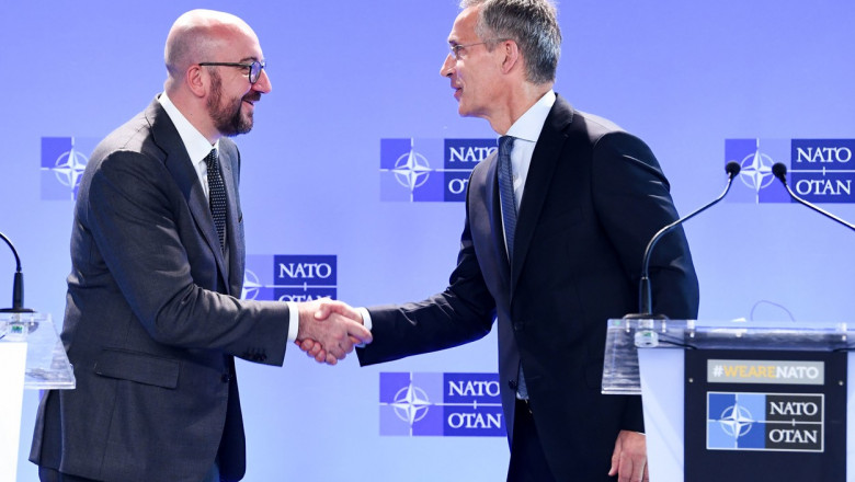 Charles Michel şi Jens Stoltenberg dau mana in timpul unei conferinte de presa sediul NATO