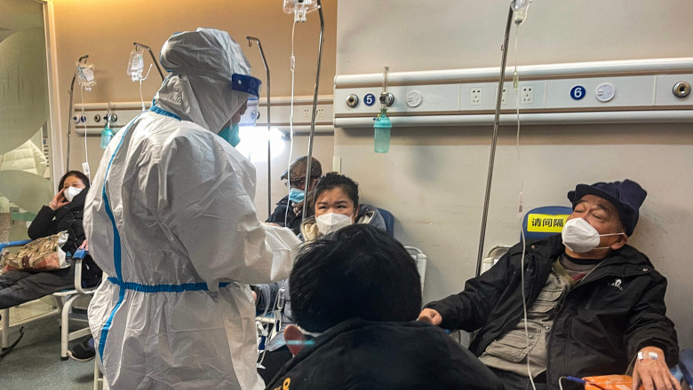 medic în costum sanitar lângă pacienți cu mască în China