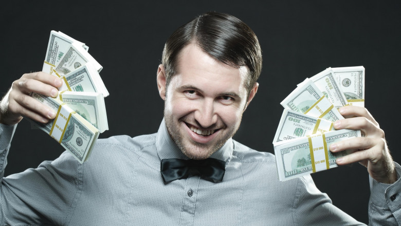 Happy man holding money isolated on black background