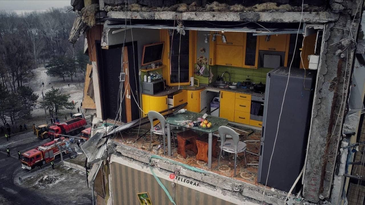 Imagine virală cu o bucătărie galbenă rămasă fără perete în blocul bombardat din Dnipro. Se văd mere pe masă și farfurii în chiuvetă