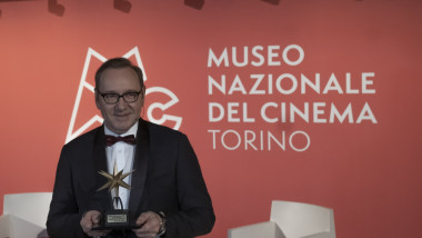 Kevin Spacey cu un trofeu în mână la un muzeu din Torino