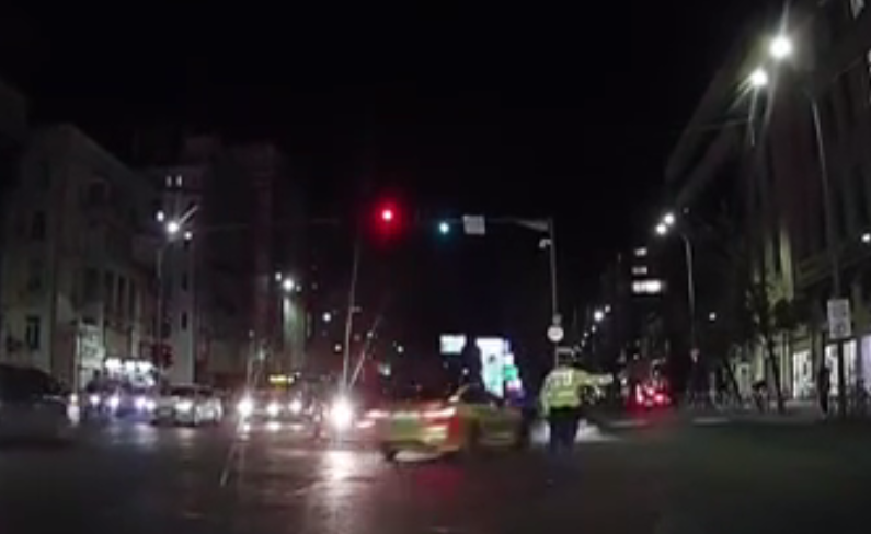 VIDEO. Șoferul unui BMW, aproape să omoare un polițist care dirija traficul în intersecţie. A intrat pe trotuar unde a lovit un pieton