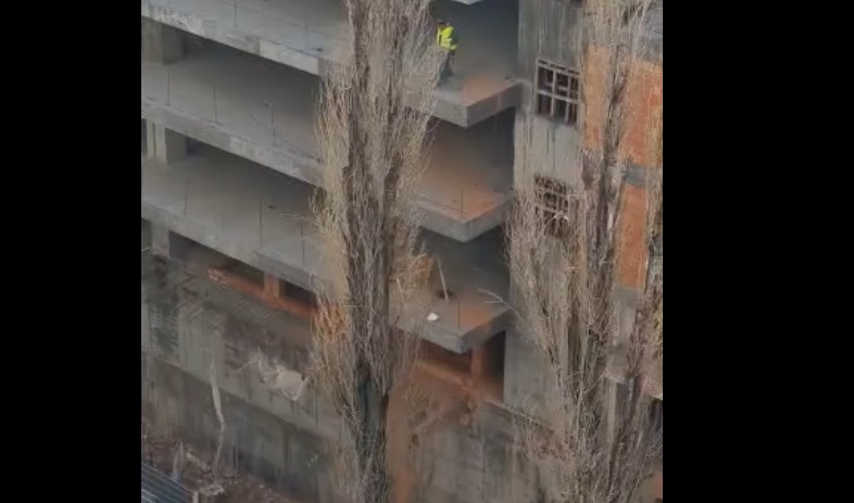 Un muncitor aruncă moloz cu roaba, de la etajul 3 al unei clădiri. Imagini filmate pe un șantier din București