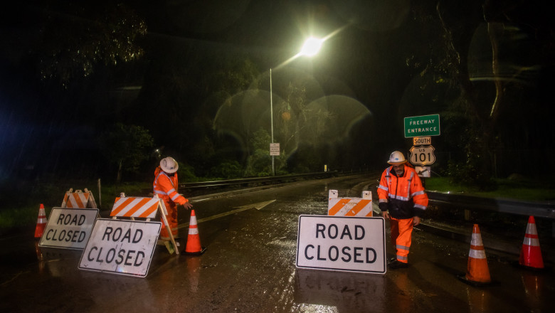 lucrători la drumuri pun semne de drum închis pe o stradă din california