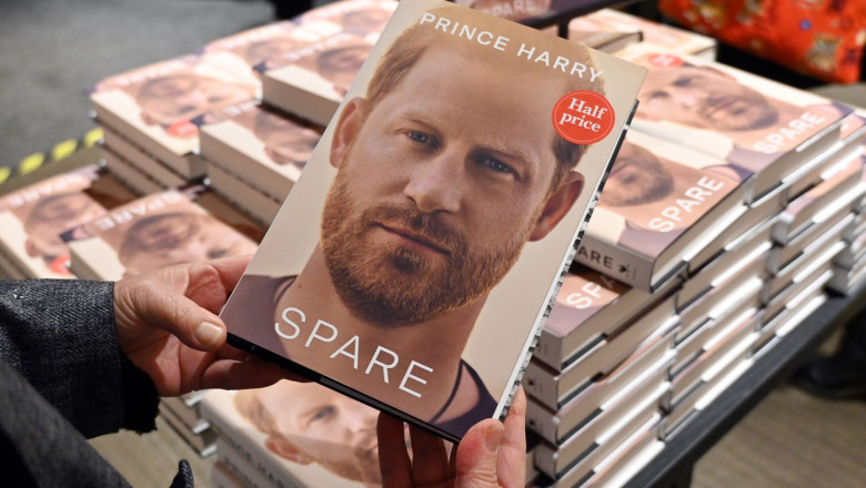 Un volum din cartea Spare a prinţului Harry este ţinut în mâini de o persoană, într-o librărie