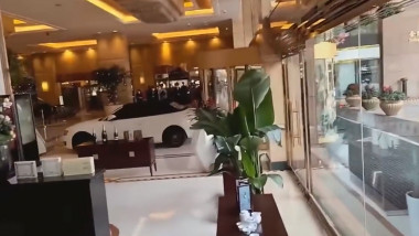 Un șofer intră cu mașina de lux în holul unui hotel