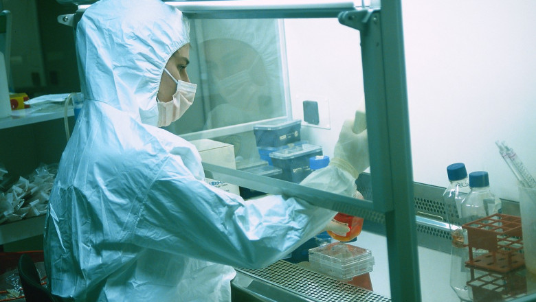 Un angajat lucrează în costum de protecție într-un laborator de cercetare genetică.