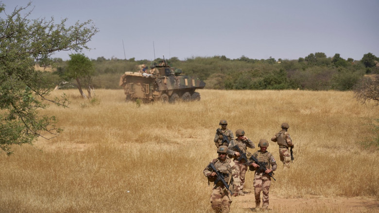 Soldați francezi patrulează pe un câmp din Burkina Faso.