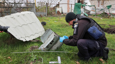 Un anchetator ucrainean pentru crime de război inspectează o rămășiță a ceea ce se crede a fi o bombă cu dispersie în regiunea Herson, care a fost distrusă de rachetele rusești