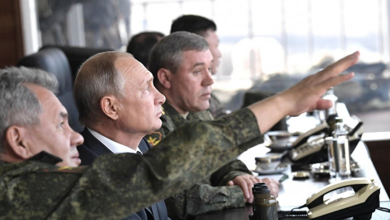 Russian President Vladimir Putin, center, with Defence Minister Sergei Shoigu, left, and Chief of the General Staff General Valery Gerasimov observe the Vostok-2018 multi-national war games at the Telemba training grounds September 13, 2018 near Chita in