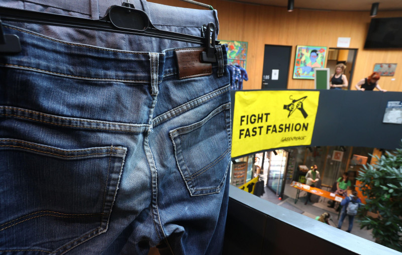 26 November 2022, Bavaria, Wrzburg: "Fight fast Fashion" reads a poster at a clothing swap party organized by Greenpeace. Photo: Karl-Josef Hildenbrand/dpa Credit: dpa picture alliance/Alamy Live News