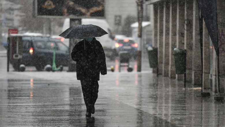 bărbat cu umbrelă pe ninsoare în bucurești