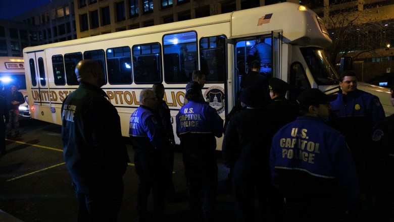polițiști de la capitoliul american în fața unui autobuz special
