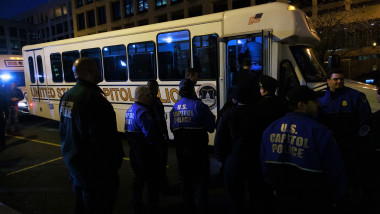 polițiști de la capitoliul american în fața unui autobuz special