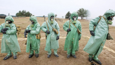 Oameni în custume de protecţie pentru radioactivitate.
