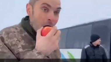 Un soldat ucrainean mușcă dintr-un măr
