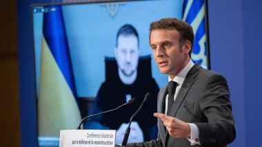 Preşedintele Franţei, Emmanuel Macron vorbeşte la un pupitru având pe fundal un ecran în care apare preşedintele Ucrainei, Volodimir Zelenski.