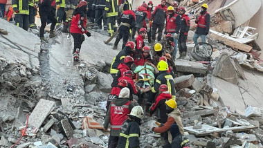 Salvatorii scot persoane de sub dărâmăturile unei clădiri prăbușite în Turcia.