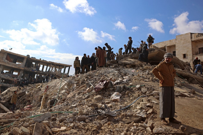 ruine și oameni încercănd să îndepărteze dărâmături în Siria