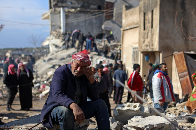 bărbat în vârstă plânge în timp ce stă pe ruine în Siria