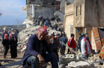 bărbat în vârstă plânge în timp ce stă pe ruine în Siria