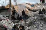 ruine și oameni încercănd să îndepărteze dărâmături în Siria