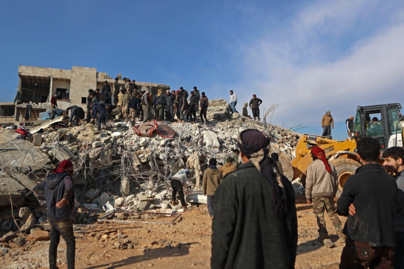 ruine și oameni încercând să îndepărteze dărâmături în Siria